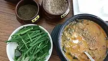 Chueo-tang served with ground chopi, ground perilla seeds, and garlic chives